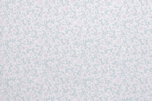 Tapetissa on pieniä vaaleanpunaisia kukkia ja vihreitä lehtiä valkoisella pohjalla.