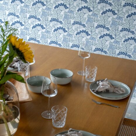 Soili 3 Tapetissa on vaaleansinisiä marjoja, tummansinisiä kukkia ja vaaleanvihreitä lehtiä valkoisella pohjalla.