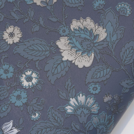 Sinikka tummansininen Tapetissa on tummia, petroolin- ja harmaansinisen sävyisiä kukkia tummansinisellä pohjalla.